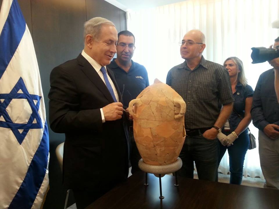 Israeli Prime-Minister Benjamin Netanyahu examines the Eshbaal inscription in his office.